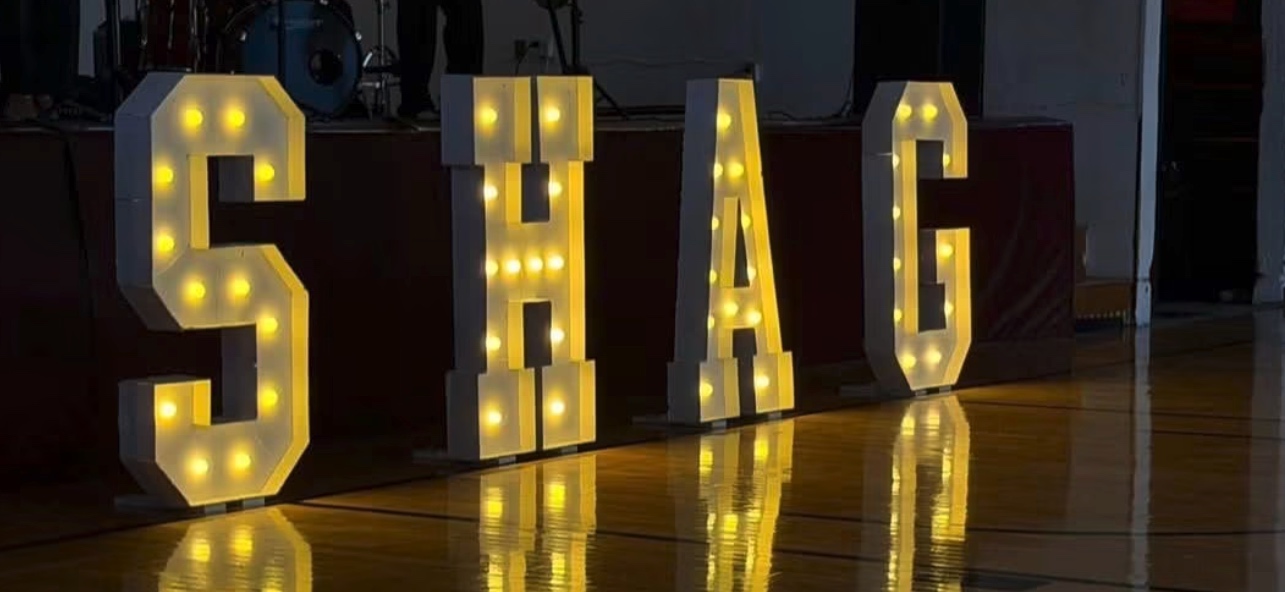 Illuminated marquee letters spelling SHAG on the dance floor at a Bluefield Area Shag Society event
